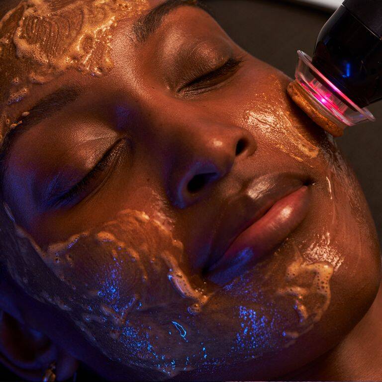 Woman smiling while getting a GLO2Facial